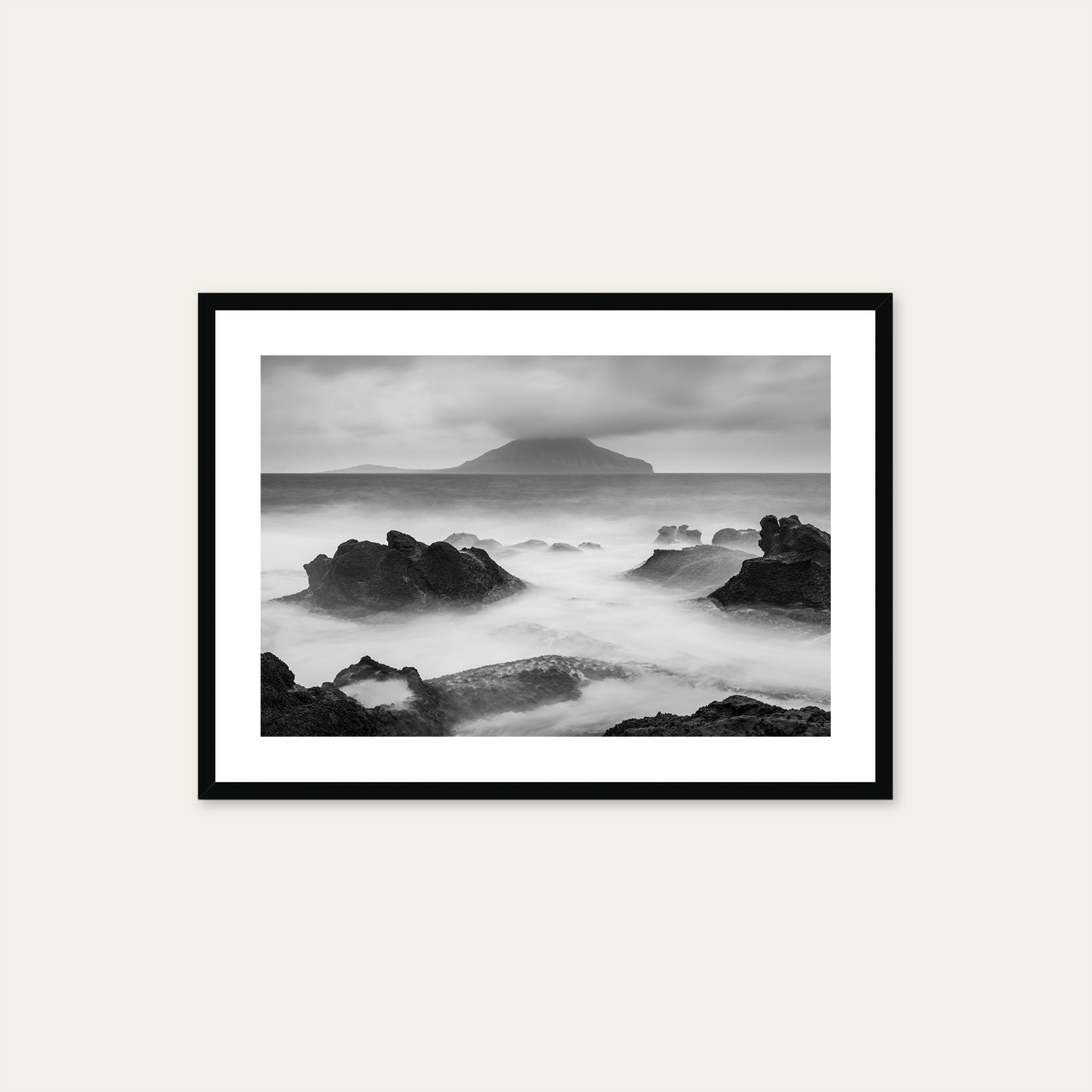 A black framed print of a rugged shoreline on the Faroe Islands