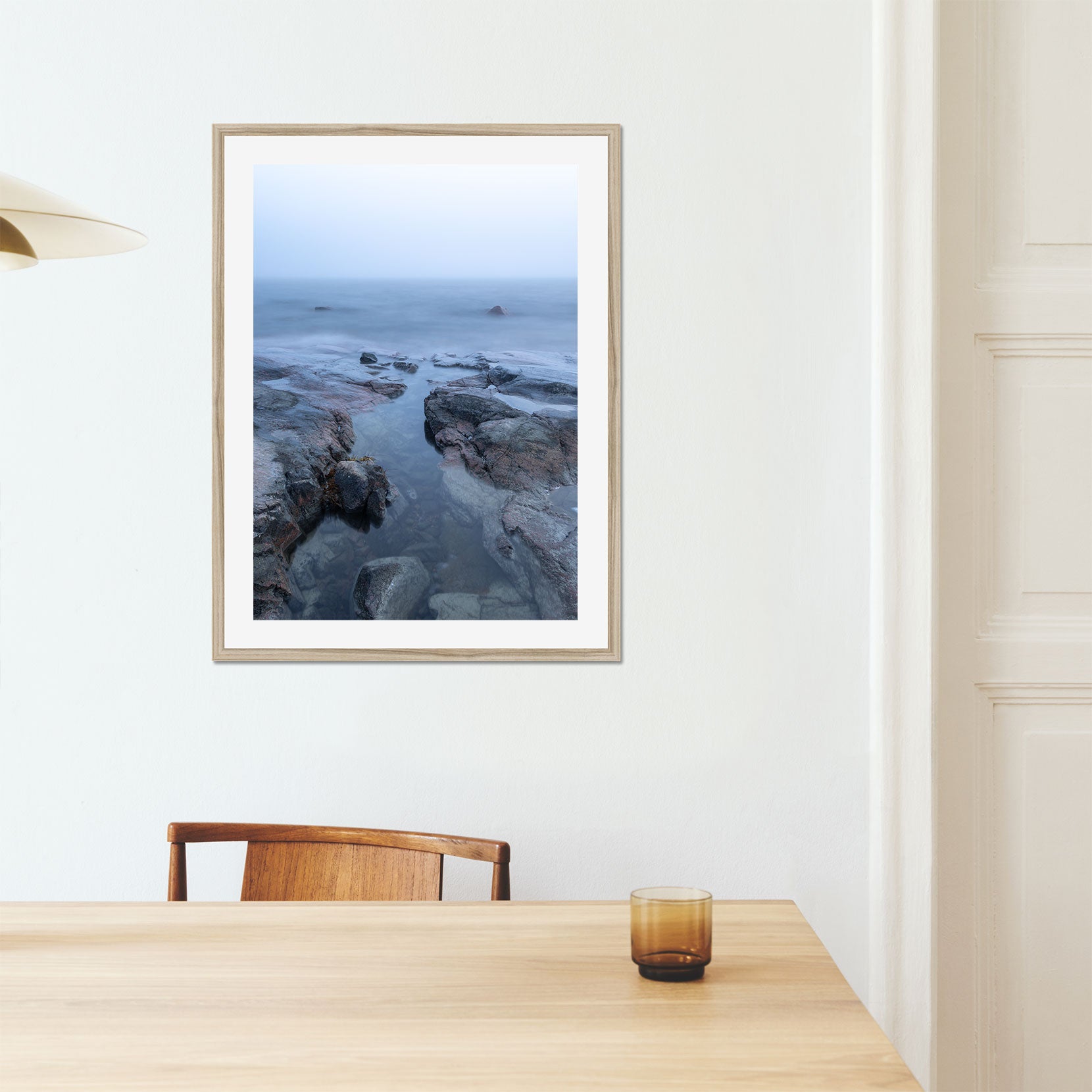 A framed print of a rocky coastline in fog