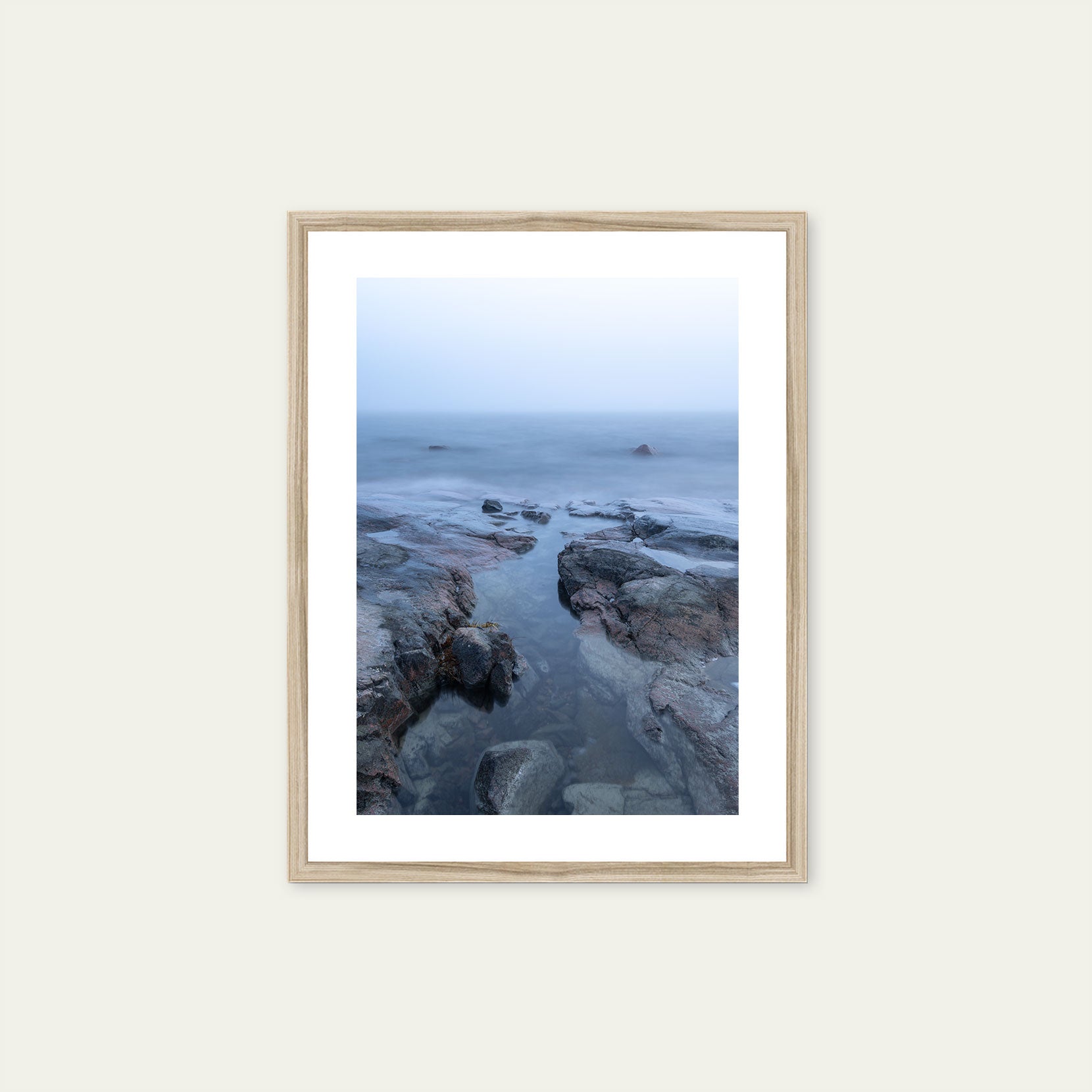 A wood framed print of a rocky coastline in fog