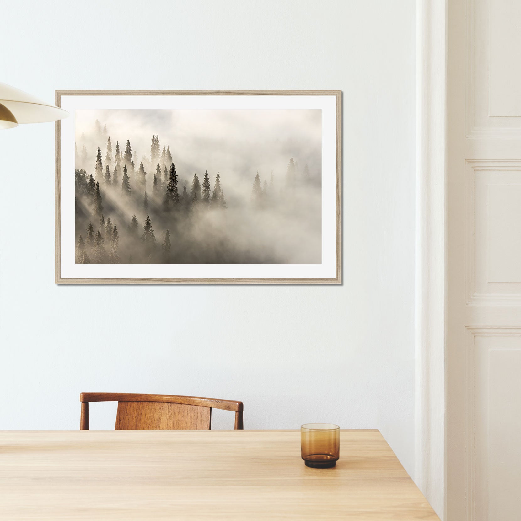 A framed print of a fog covered forest at dawn