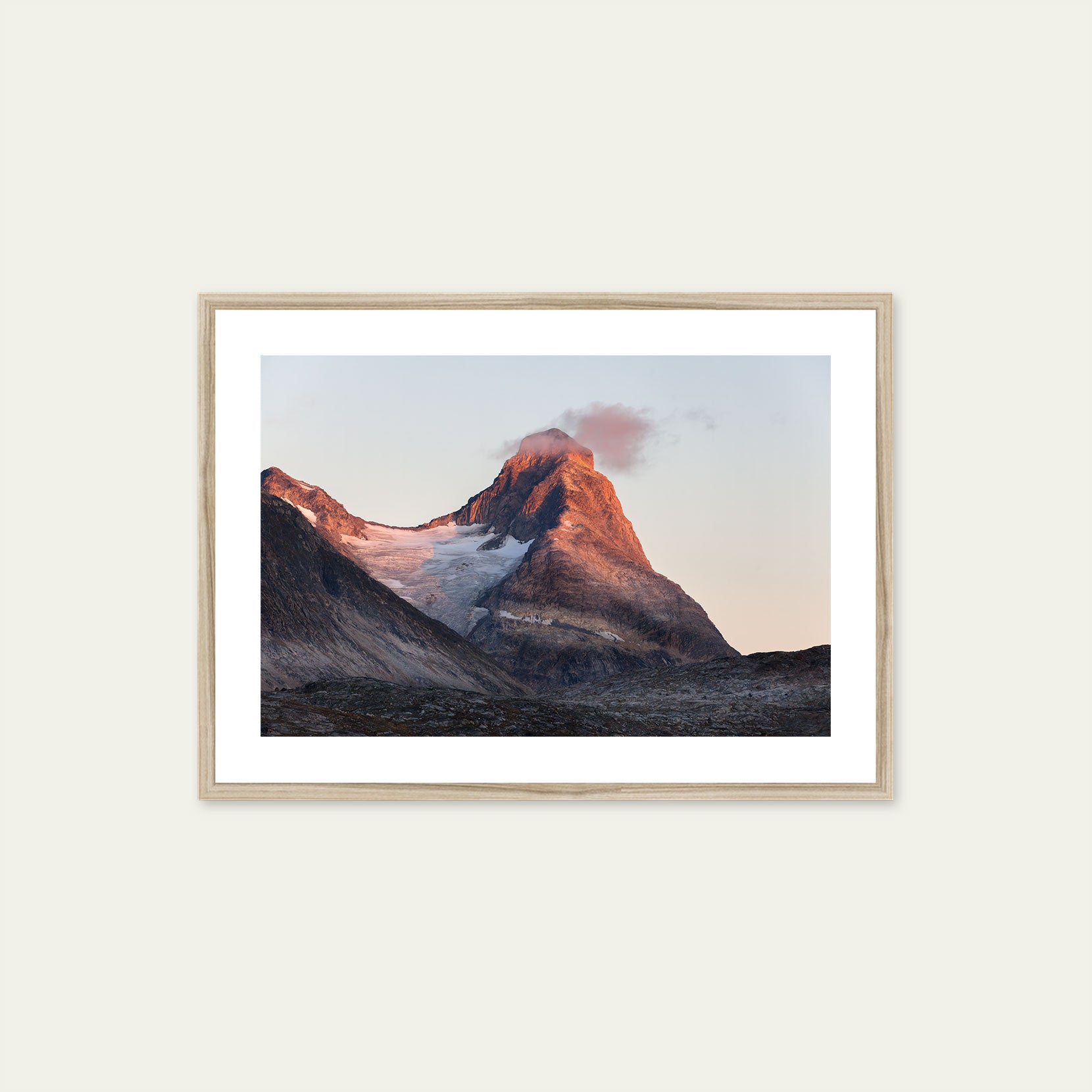 A wood framed print of a mountain peak at sunset