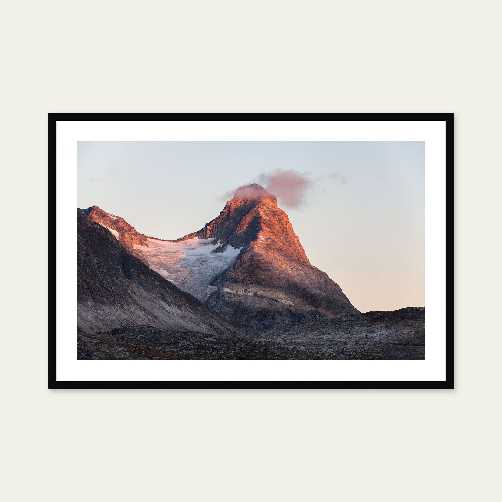 A black framed print of a mountain peak at sunset