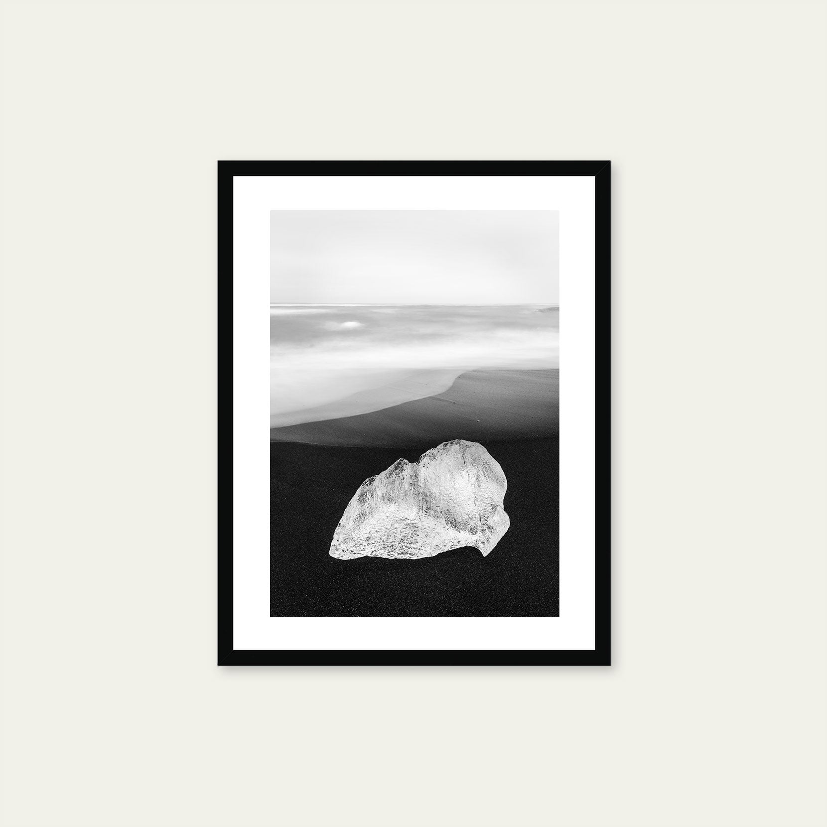 A black framed print of a ice on black sand beach