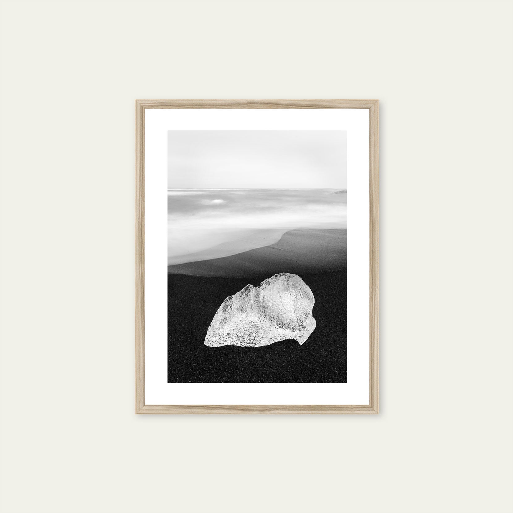 A wood framed print of a ice on black sand beach