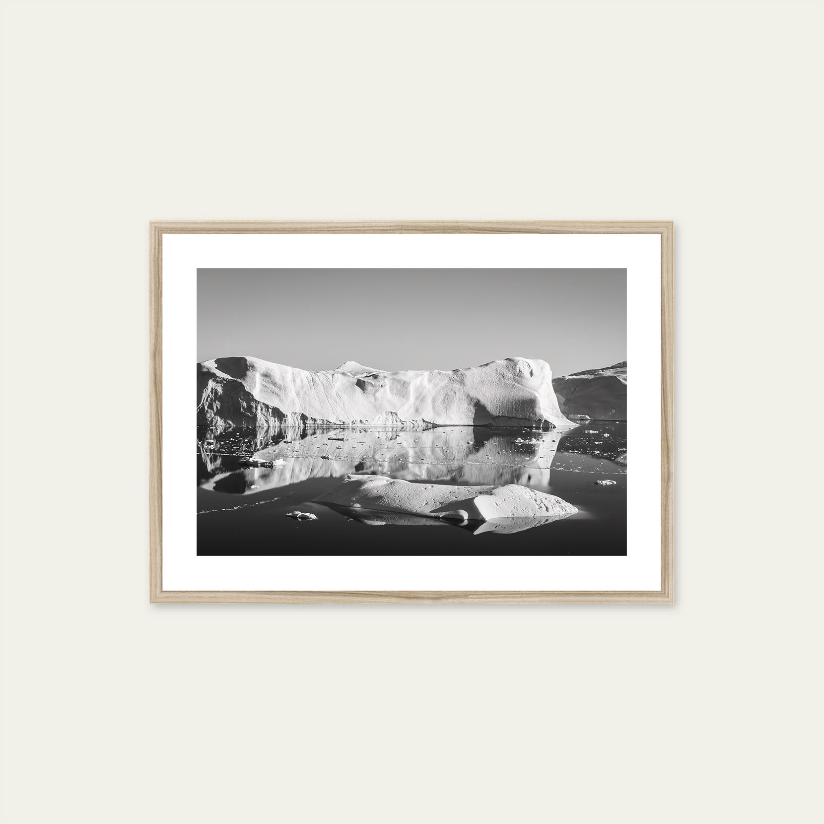 A wood framed black and white print of icebergs in Greenland
