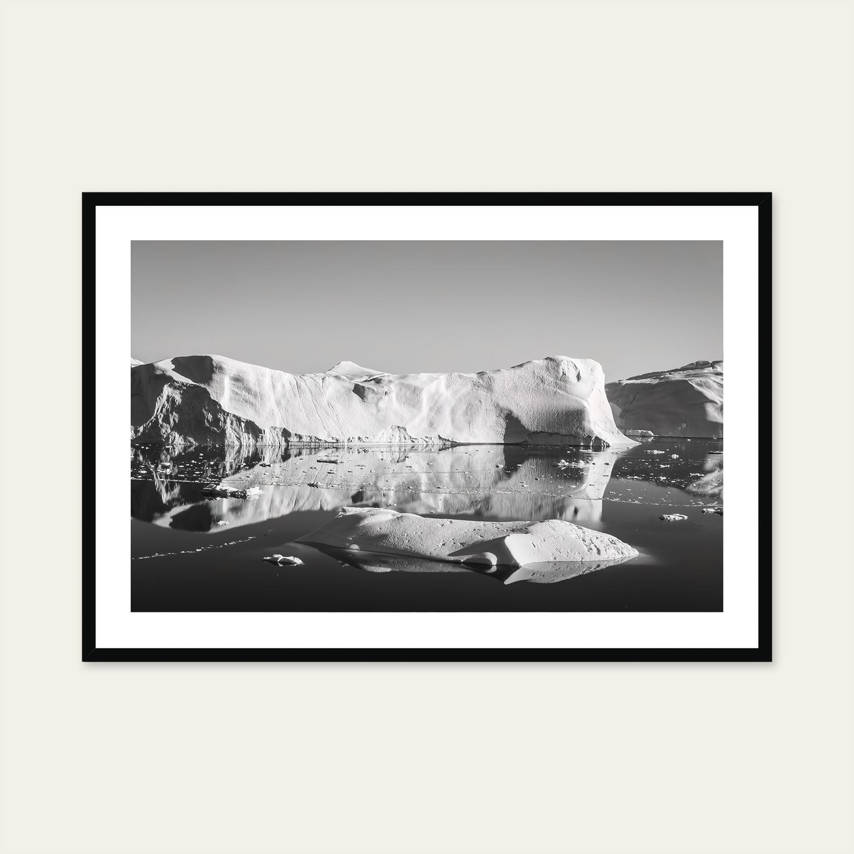 A black framed black and white print of icebergs in Greenland