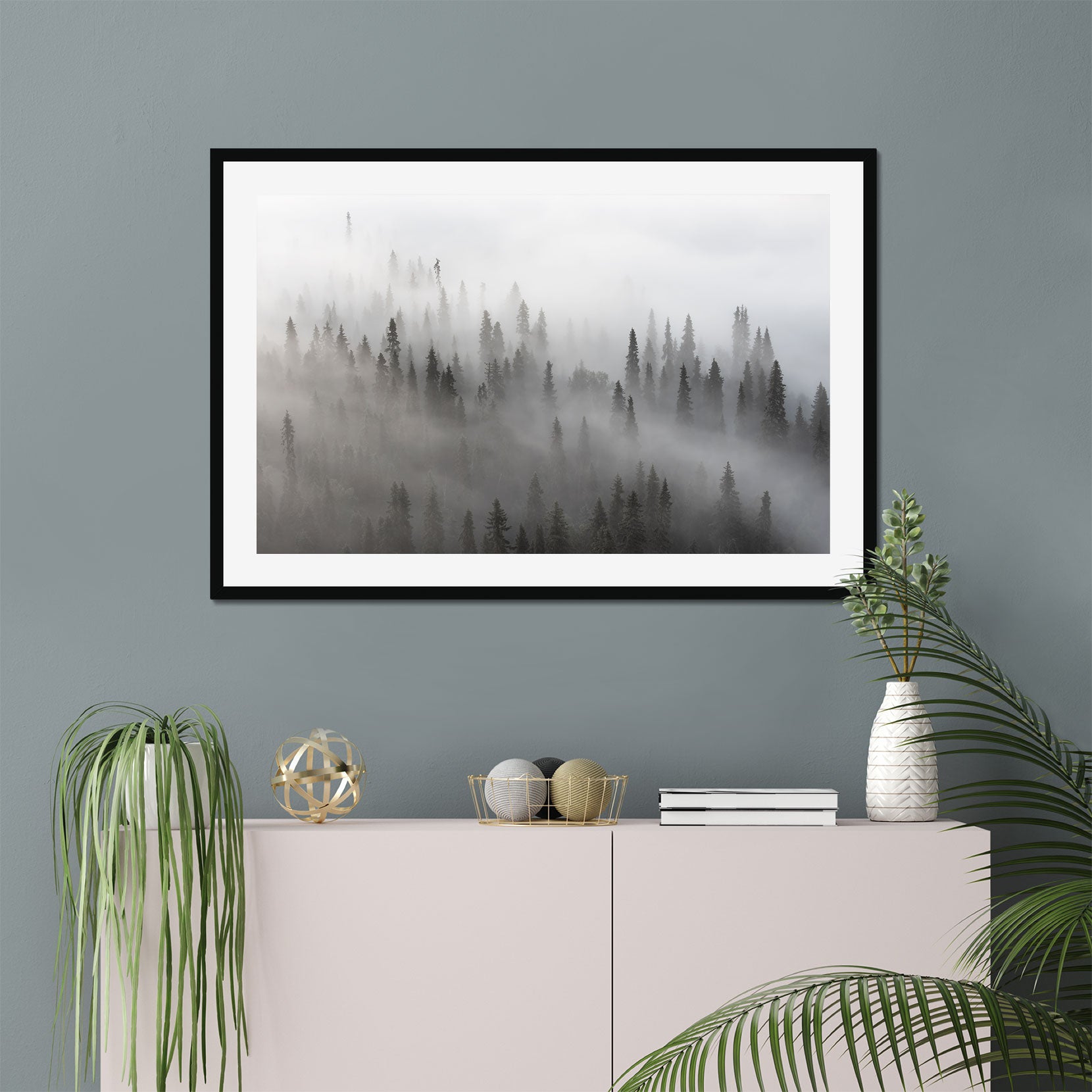 A framed print of a forest with lingering fog