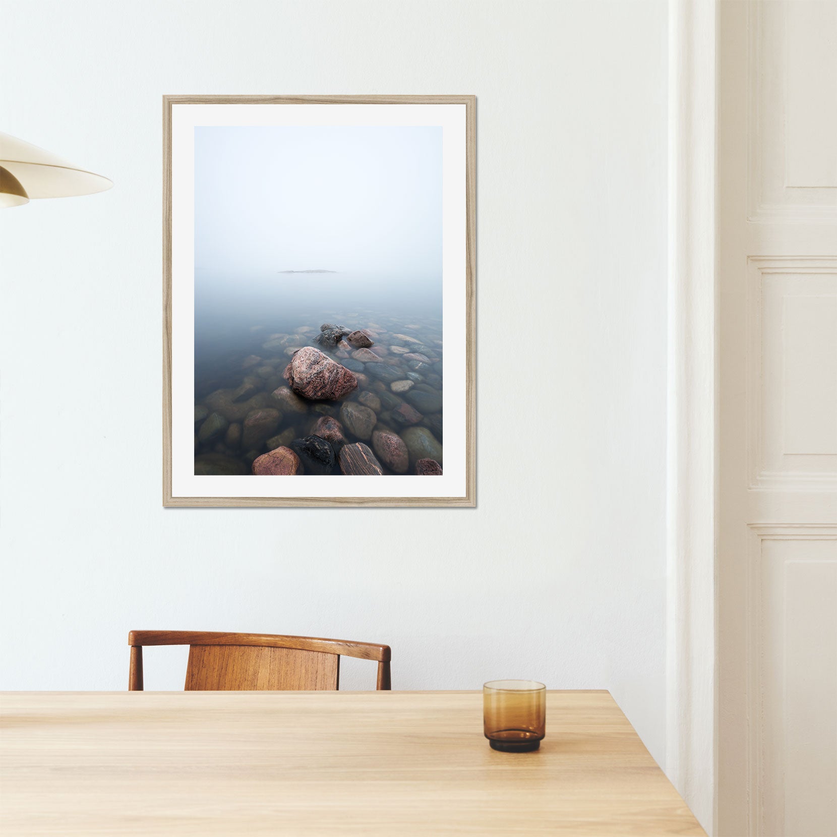 A framed print of rocks in the sea on a foggy day