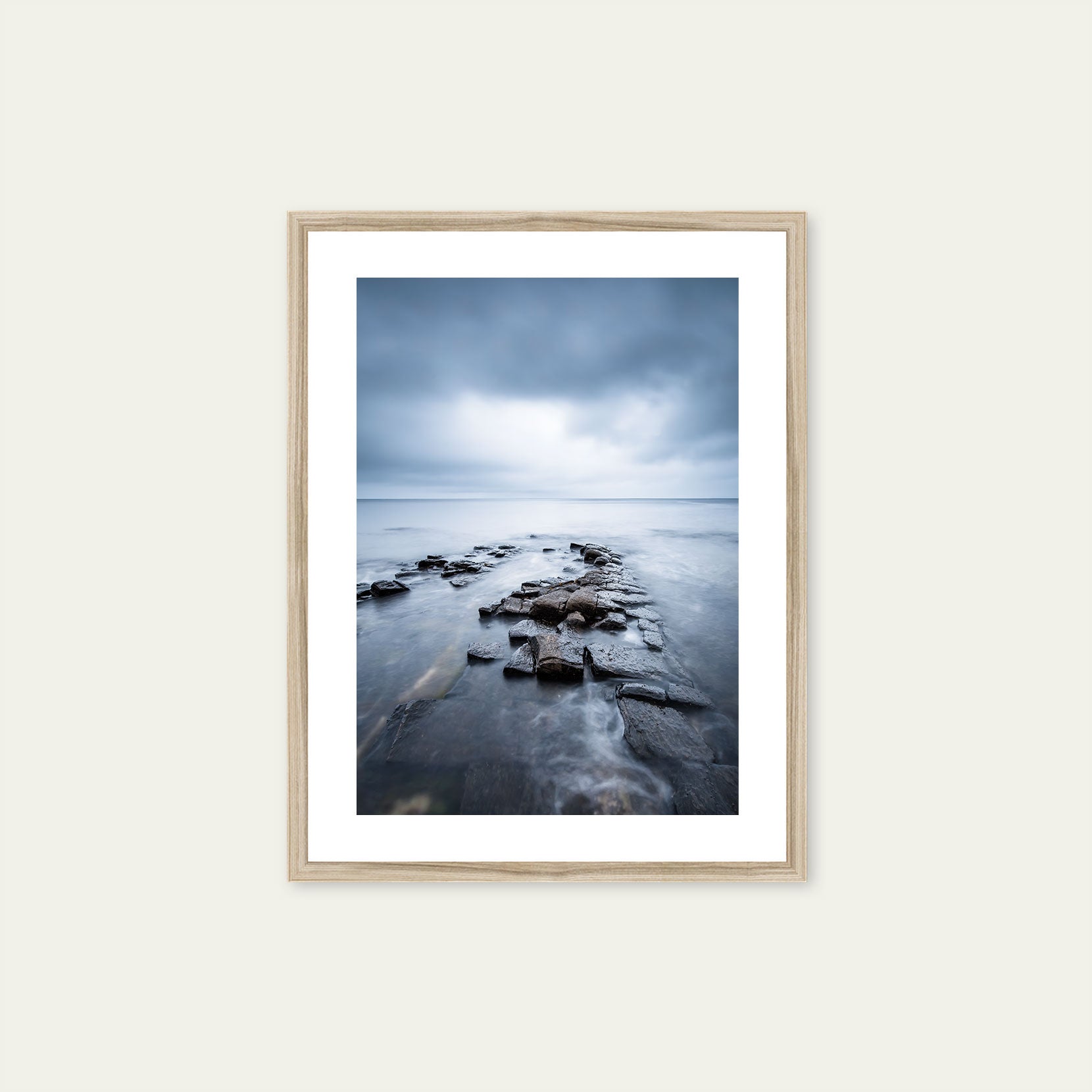 A wood framed print of a moody seascape in Norway