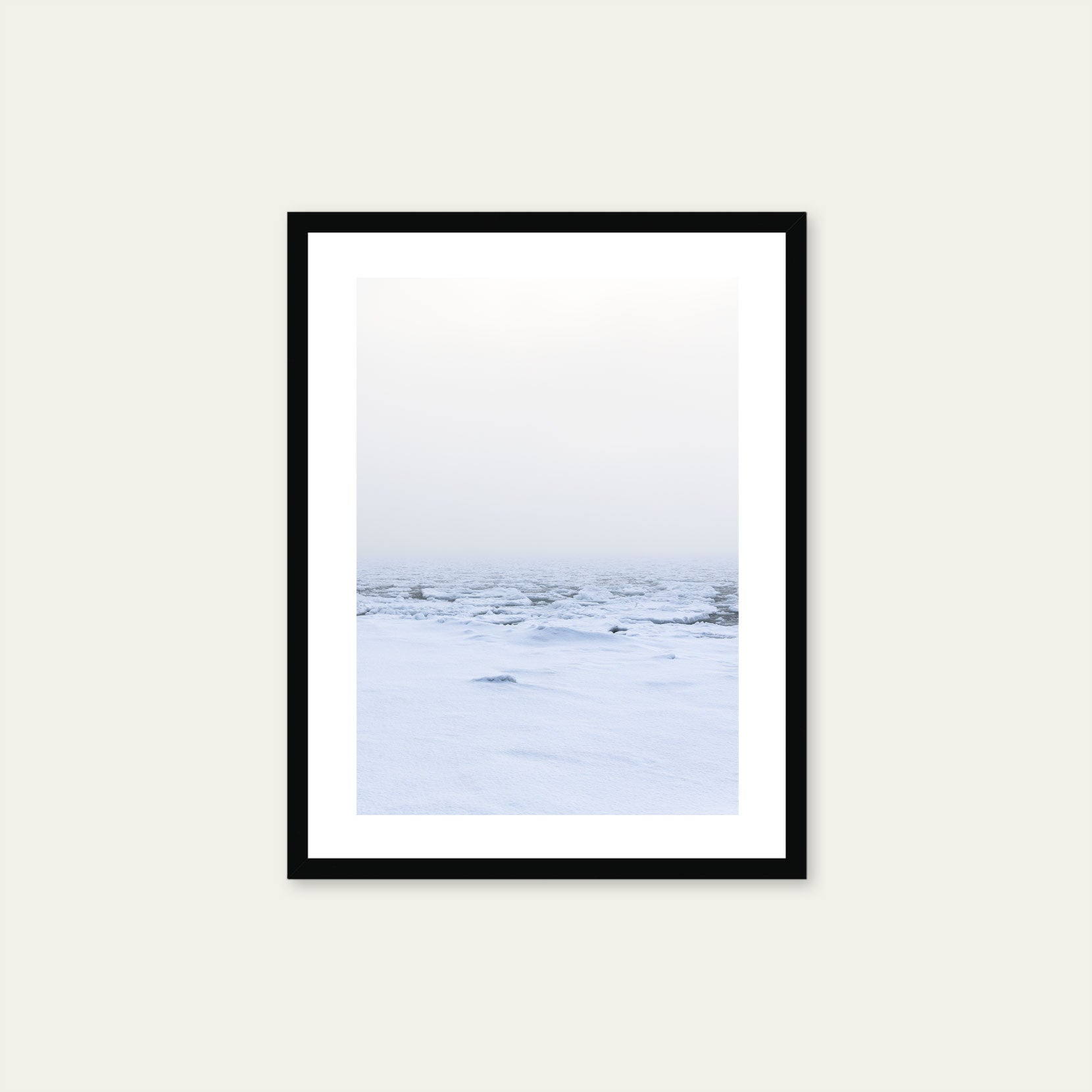 A black framed print of a snow covered shoreline with fog