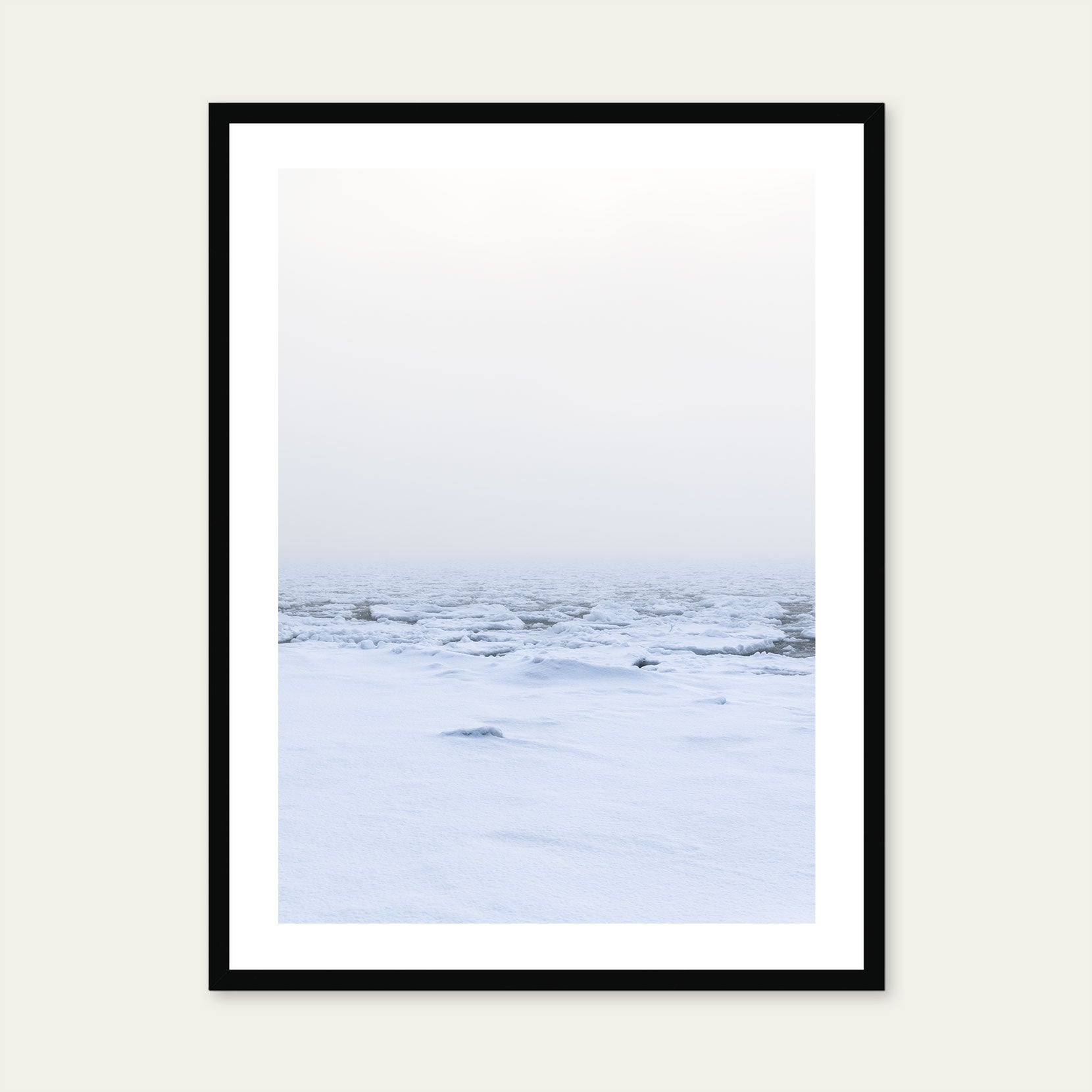 A black framed print of a snow covered shoreline with fog