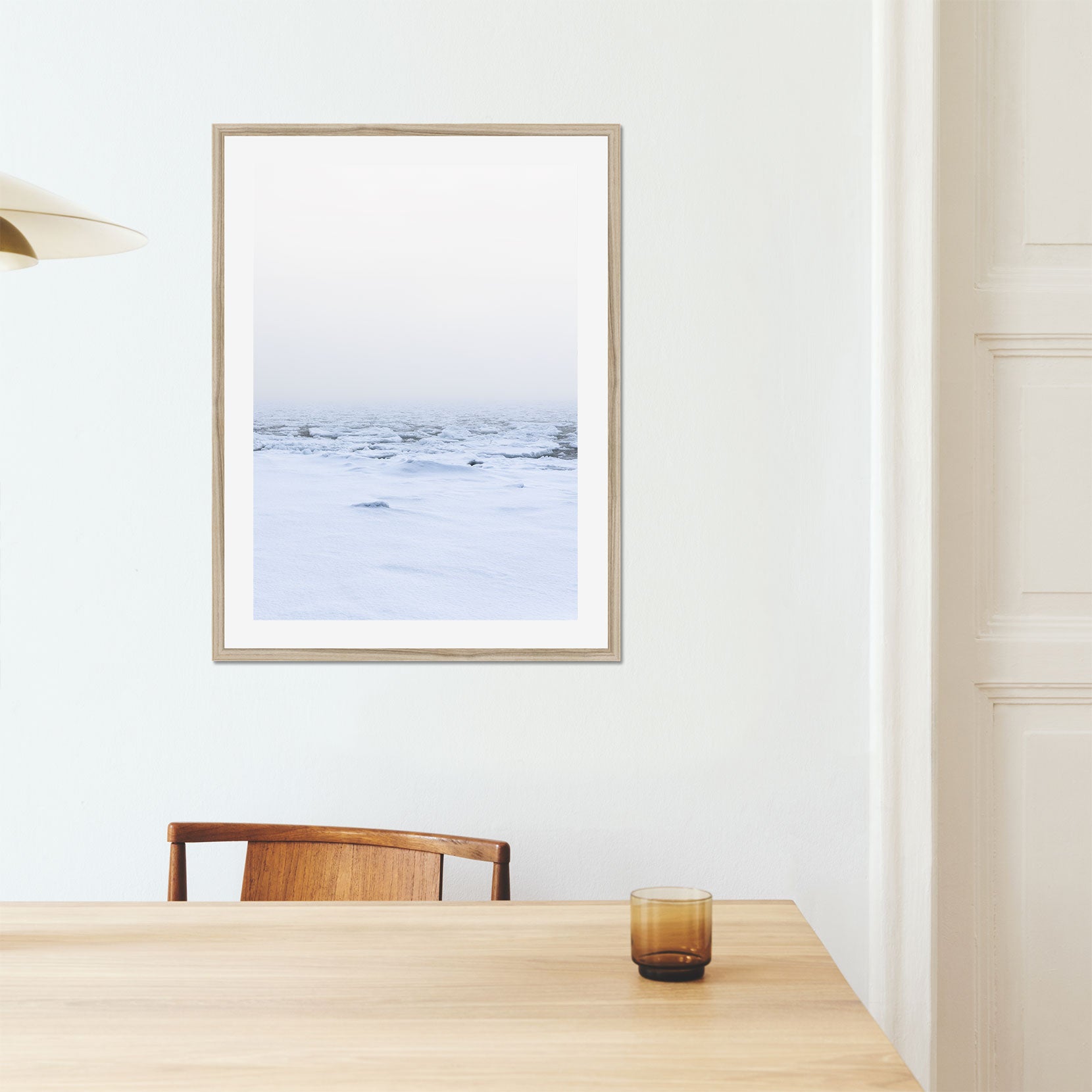 A framed print of a snow covered shoreline with fog