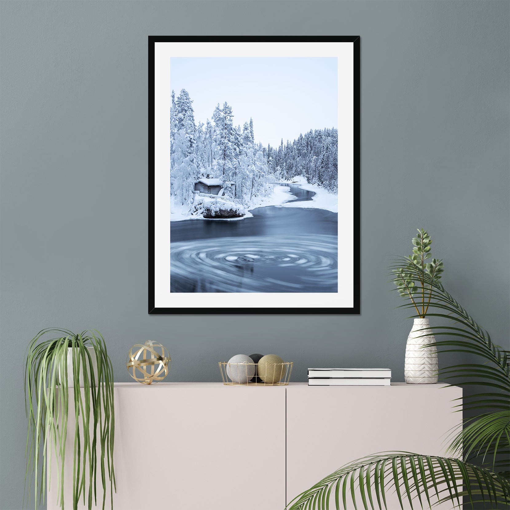 A framed print of a wooden hut in winter forest